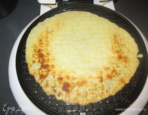 Вафельницу смазать растительным маслом с обеих сторон и выпекаем вафли, выкладывая в форму примерно по 1,5 столовой ложке теста. Выпекаем около 2 минут.