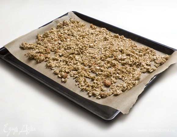 Равномерно выложить получившуюся массу на застеленный бумагой для запекания противень и отправить в духовку, разогретую до 180° C, на 10 минут. Затем вынуть мюсли из духовки, перемешать и еще раз поместить в духовку на 15 минут (периодически доставать и перемешивать).