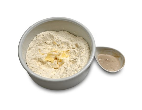 Дрожжи развести в 150 мл теплой воды, подождать 10 минут, затем перемешать. В глубокую емкость просеять муку, добавить 30 г сливочного масла и тщательно растереть его вместе с мукой.

