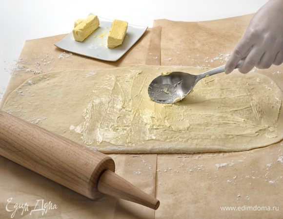 Намазать 1/3 масла на 2/3 поверхности теста, отступив от краев по 2 см. Несмазанную поверхность завернуть на половину смазанной поверхности и прикрыть оставшейся смазанной поверхностью.
