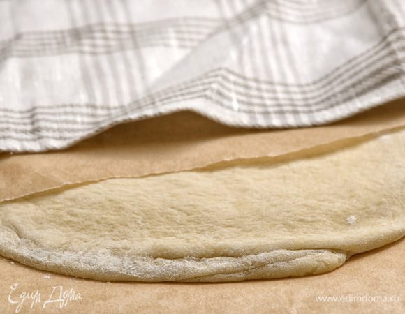 Накрыть тесто листом бумаги для запекания и полотенцем. Отправить в холодильник на 30 минут. Затем повторить весь цикл еще 2 раза, используя оставшиеся 2 части масла. После тесто раскатать и сложить еще 3 раза, но уже без масла и поместить на 30 минут в холодильник.
