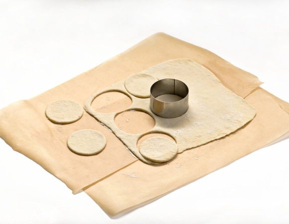 Тонко раскатать лист теста. Стаканом вырезать кружочки.


