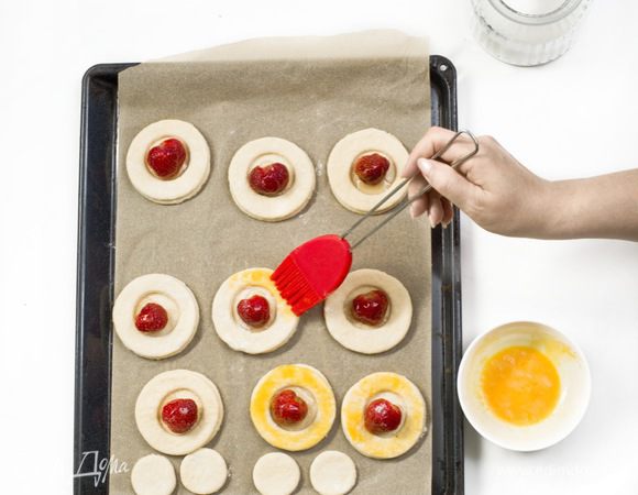 Края пирожных смазать желтком и посыпать сахаром.
