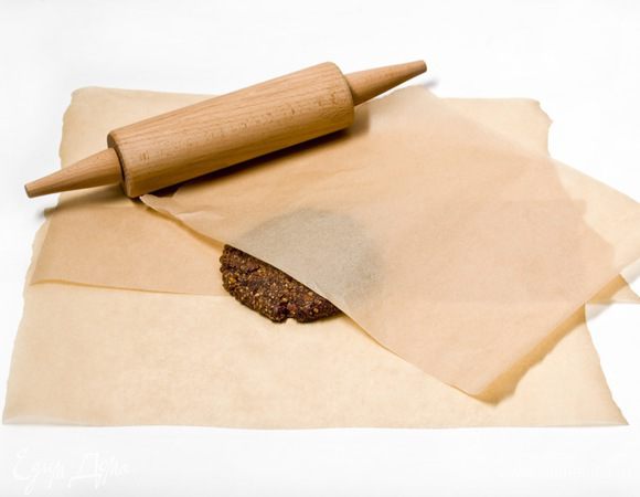 Выложить ореховую смесь между двумя листами пергаментной бумаги и раскатать пласт теста, толщиной 1,5 см.
