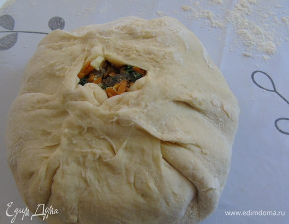 Выкладываем горкой начинку на середину и заворачиваем края теста обтягивая начинку, в центре оставляем отверстие для выхода пара.