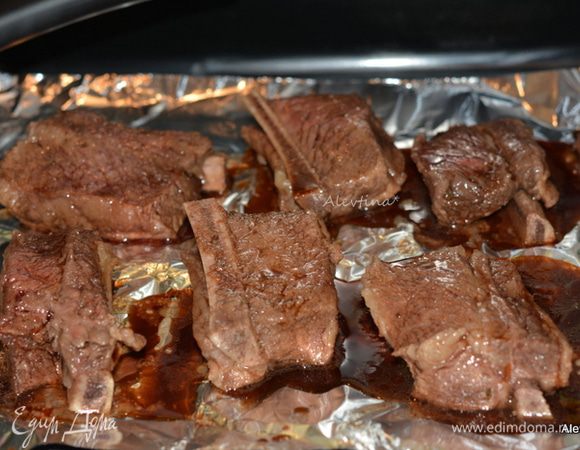 Выкладывать ребрышки на противень застеленный фольгой. Поставить в разогретую духовку на 180°С, прикрыв фольгой сверху на 2 часа. Каждый час или полчаса поливать смесью и переворачивать ребрышки.