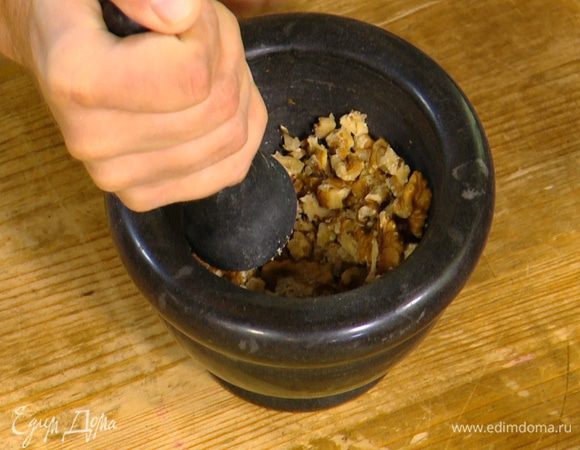 Грецкие орехи измельчить в ступке.