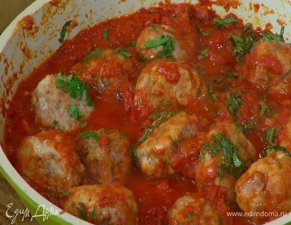 Подпеченные тефтели выложить в сковороду с соусом, добавить петрушку, все перемешать и тушить под крышкой почти до готовности.