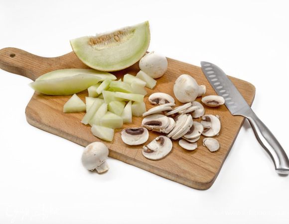 Дыню нарезать кубиками. Грибы вымыть, очистить от кожицы, удалить ножки и нарезать тонкими пластинами.

