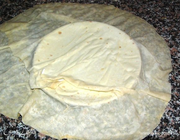 Лист теста фило разложим на столе. Я, для удобства, подставляю под низ большую тарелку, совпадающую по размеру со сковородой, на которой будем обжаривать лепешку. 