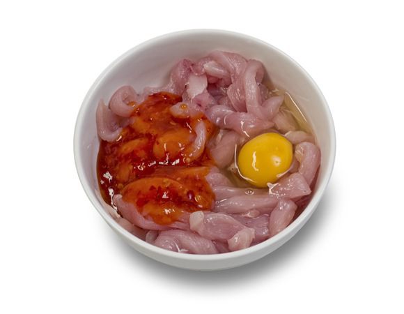 Куриное филе нарезать соломкой, посолить, поперчить, добавить соус чили, кунжутное масло и яйцо. Перемешать и оставить мариноваться на час.
