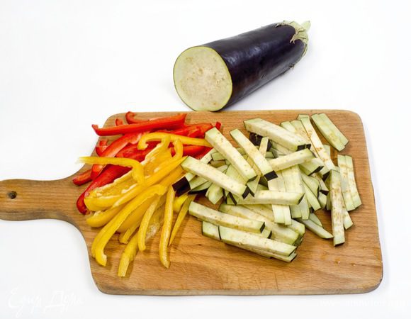 Баклажаны и перец нарезать соломкой. Чеснок и зелень для украшения мелко порубить.
