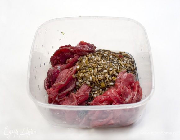 Нарезанное мясо поместить в пластиковый контейнер. Чеснок, лук и имбирь натереть на мелкой терке, добавить 75 мл соевого соуса, 50 мл кунжутного масла, все перемешать и вылить в контейнер с мясом. Поставить в холодильник на 1 час.