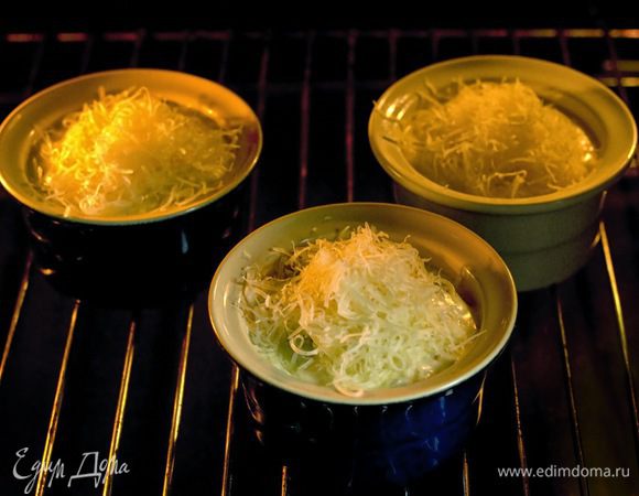 Выложить морепродукты с соусом в формочки для жюльена, посыпать сыром и запекать в разогретой до 180°C духовке 5 минут.

