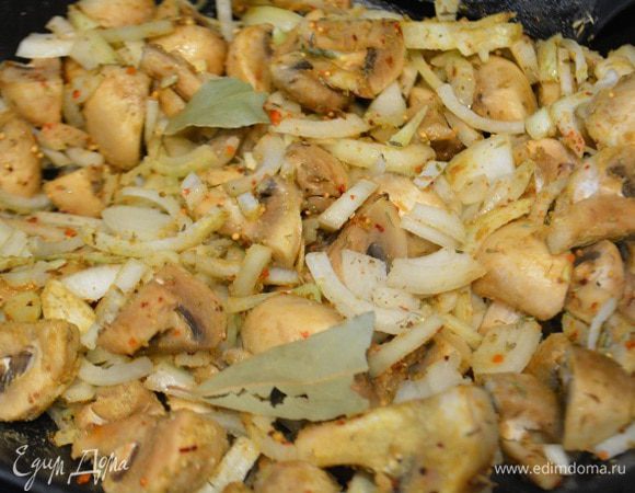 К грибам добавить лук, чеснок и специи, перемешать. Обжарить 2-3 минуты, периодически помешивая.