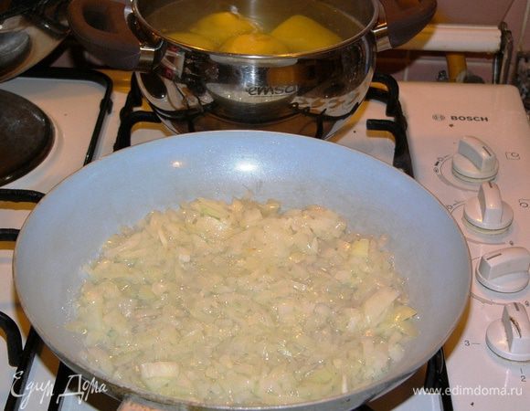 Картофель очистить и отварить. Пока варится картошка, лук очистить, мелко нарезать и обжарить на растительном масле. Нарезать петрушку. 