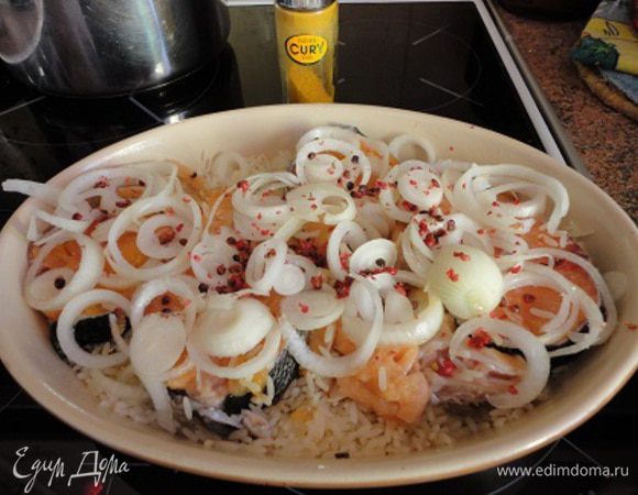 Сверху выложить рыбу одним слоем, на нее выложить нарезанный тонкими кольцами лук и посыпать перцем.