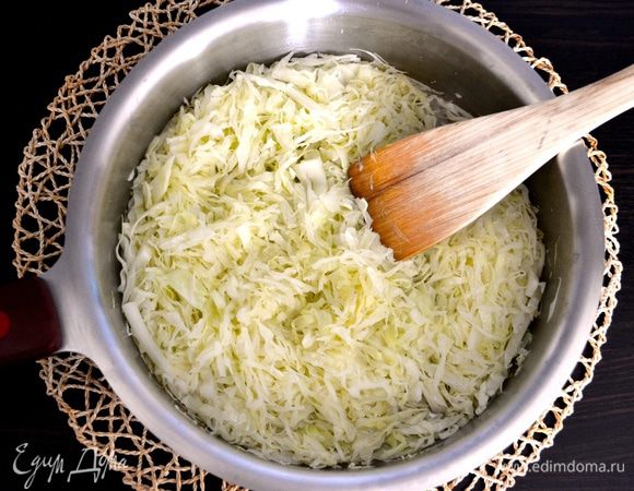 Капусту нашинкуйте соломкой. Разогрейте в сковороде масло и потушите капусту до полуготовности, около 7 минут. Снимите с огня и немного остудите.