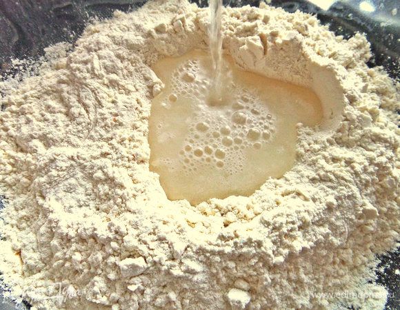 Тесто крутое постное. Вливаем в ямку из муки теплую воду.