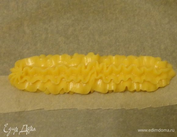 Разогреть духовку до 200°С. На противень выложить из кулинарного мешка заготовку для большого эклера.