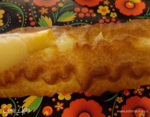 Большой эклер начинить белым кремом, маленькие эклерчики — черным.