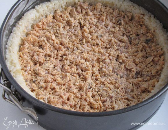 Открыть баночку лосося в собственном соку, жидкость слить, рыбу размять вилкой. Если берем свежую рыбу, то нарезаем кубиком. Выложить рыбу на рис и разровнять.