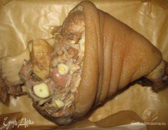 Когда рулька сварится, вынимаем ее из кастрюли и выкладываем на противень в котором будет выпекать. Воду не выливаем, ей будем поливать рульку. Рульку нашпиговать чесноком. Выпекать 40 минут, периодически поливая водой.