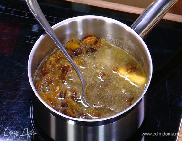 Добавить изюм, 50 г сливочного масла, сахар, влить 250 мл воды, солодовый сироп, все перемешать и прогревать 5 минут на медленном огне — вода ни в коем случае не должна кипеть.