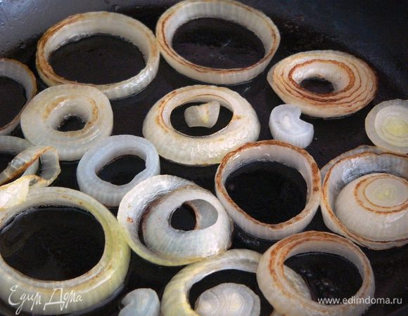 Жарим лук под крышкой на небольшом огне примерно по 2 минуты с каждой стороны до карамельного цвета.