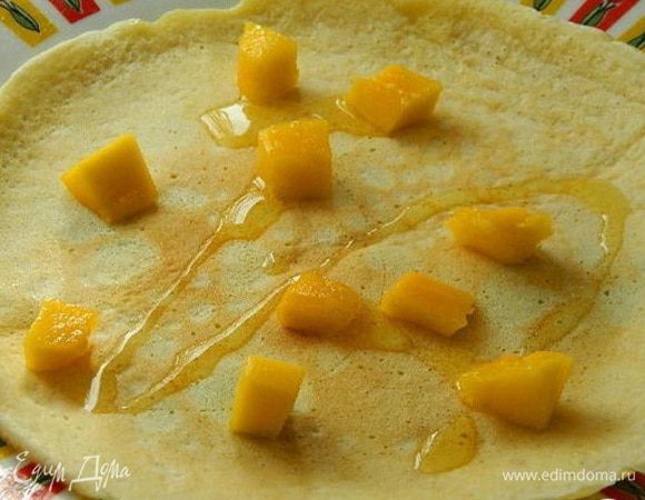 Манго почистить и удалить косточку, порезать кубиками. На блин выложить манго, полить медом.