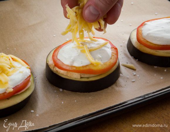 Смазываем соусом помидоры и посыпаем тертым сыром.
