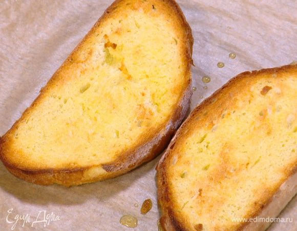 Противень выстелить бумагой для выпечки, выложить хлеб, сбрызнуть его с двух сторон оливковым маслом и отправить под гриль.