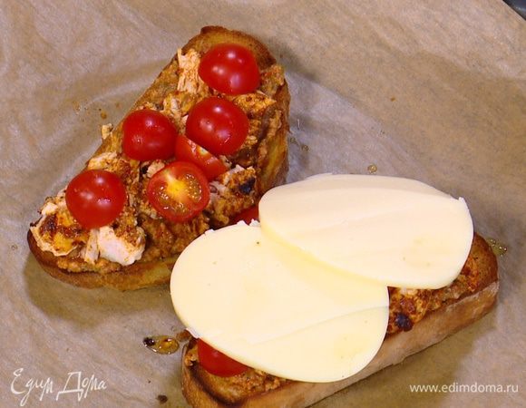 Обжаренный хлеб смазать соусом песто, сверху выложить куриное мясо, на него поместить помидоры и накрыть все кружками моцареллы.