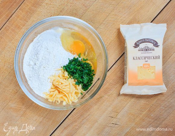 Сыр натереть на терке. Смешать сыр и яйца. Попробуйте в качестве ингредиента сыр "Брест-Литовск", пирог получится очень сочным.
Добавить к яично-сырной массе творог (лучше брать не водянистый творог). Перемешать. Зелень мелко нарезать и добавить к сырной смеси.