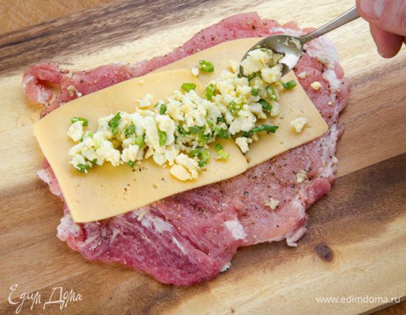 Сыр нарезать тонкими пластинами. На одну отбивную выложить полоску сыра, а поверх яичную начинку. Хороший сливочный сыр оттенит вкус закуски.