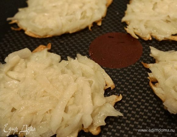 Наливаем немного масла на сковороду, где жарился бекон, и начинаем готовить драники. Выкладываем смесь столовой ложкой и прижимаем ее, формируя тонкий круглый оладушек. 