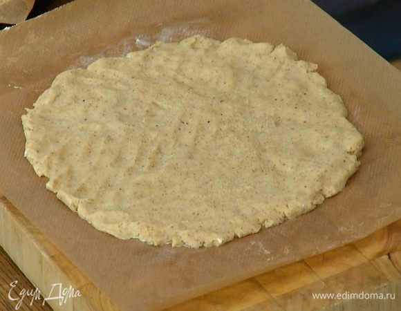 Второй лист пищевой бумаги смазать оставшимся сливочным маслом и выложить меньшую часть теста, так чтобы получилась ровная лепешка.