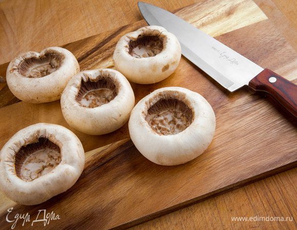 Шампиньоны вымыть, отделить ножки от шляпок. Шляпки грибов почистить, аккуратно вырезать мякоть, чтобы не повредить шляпки. 