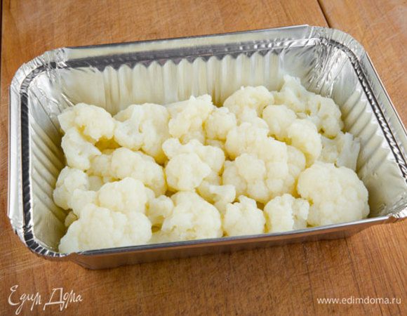 Капусту разбираем на соцветия и отвариваем в течение 10–15 минут, до неполной готовности. Форму смазываем оливковым маслом, укладываем в нее цветную капусту, желательно в один слой. Разогреваем духовку до 185 °С.