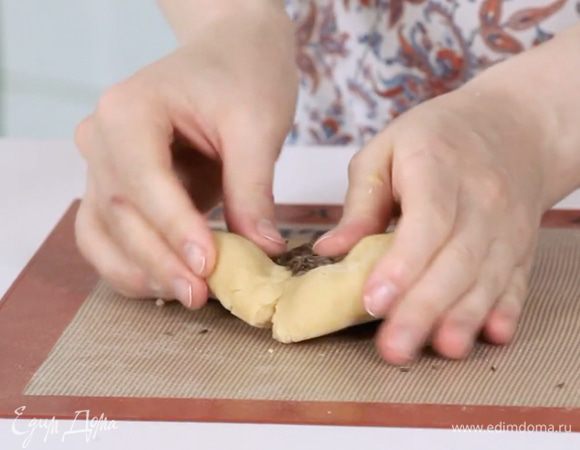 Разделить готовое тесто на 2 части. В одну вмешать сушёные ягоды, в другую — тмин.