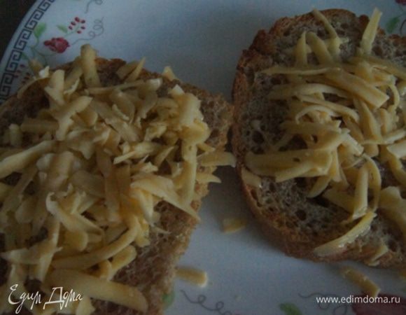 Сыр натереть на крупной терке. Хлеб поставить в тостер. Когда хлеб будет готов (я лишь слегка подсушила), сразу присыпаем оба кусочка сыром, чтобы сыр немного поплыл.