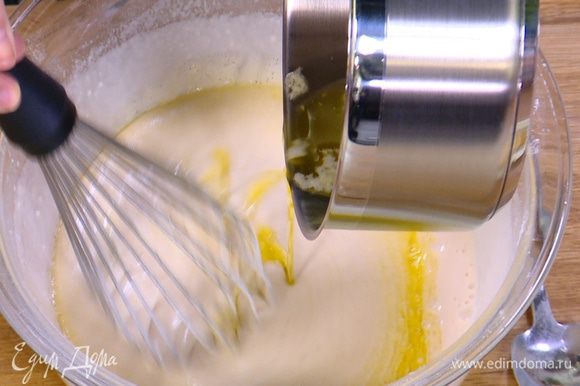 Влить в тесто 2/3 растопленного сливочного масла и перемешать венчиком.