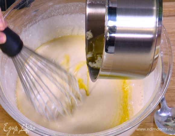 Влить в тесто 2/3 растопленного сливочного масла и перемешать венчиком.