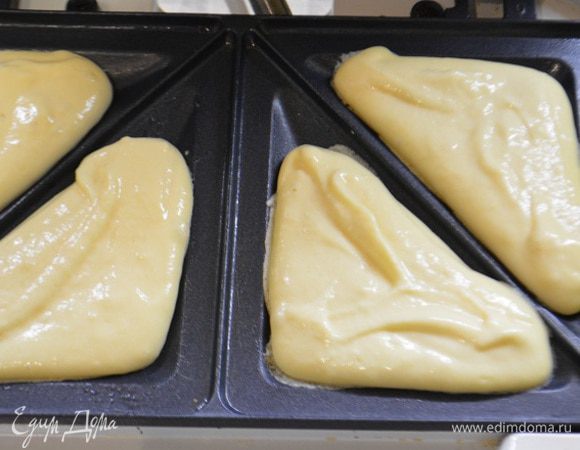 Сэндвичницу нагреть и смазать маслом с помощью кисточки.Выложить тесто в ячейки,получается по 1,5 ст.л. (на фото по 1 ст.л, я потом докладывала до конца).