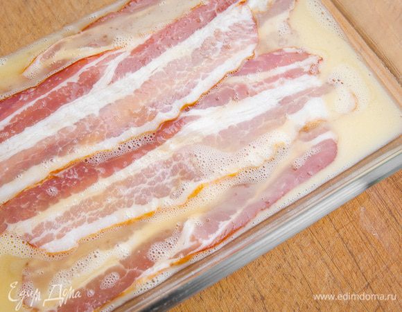Полоски бекона смочить в предварительно взбитых яйцах.