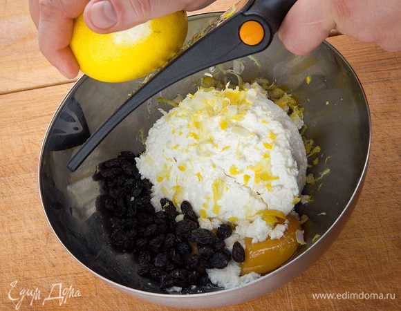 Желток вводим в творог. Добавляем изюм и цедру.
