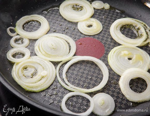 Готовим начинку. В большой сковороде на среднем огне разогреваем оливковое масло. Добавляем нарезанный кольцами лук и обжариваем его до мягкости около 5 минут.