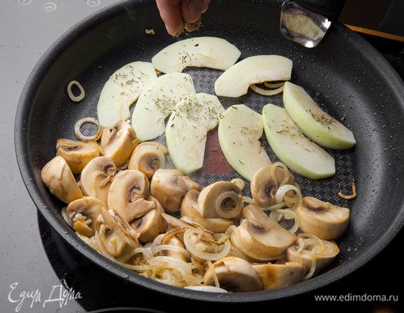 Добавляем измельченный чеснок, крупно нарезанные грибы и одно яблоко, а также розмарин. Обжариваем, периодически помешивая. Солим и перчим. Снимаем с огня и даем полностью остыть.