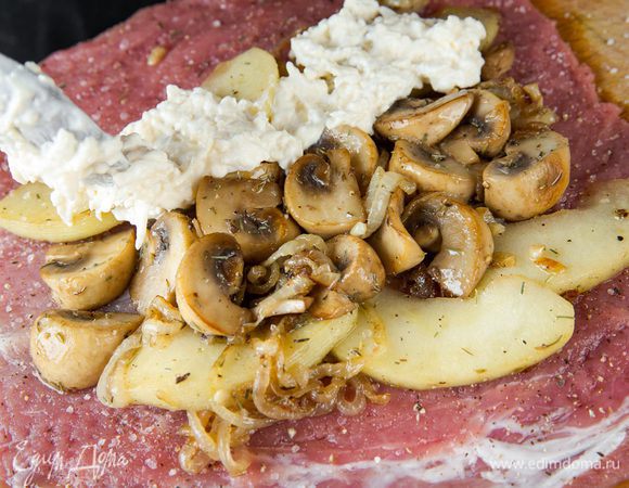 Равномерно распределяем начинку из овощей и грибов по мясу, сверху кладем сметанно-сырную смесь.