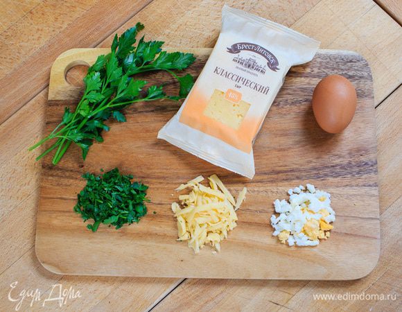 Делаем начинку. 
Два яйца отварить, порезать на маленькие части. Сыр натереть на терке.
Зелень мелко порезать. Такая начинка с сыром превратит пирог в настоящее лакомство!

